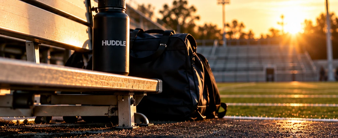 Concept photograph of a stadium bench, team bag and water bottle at sunset